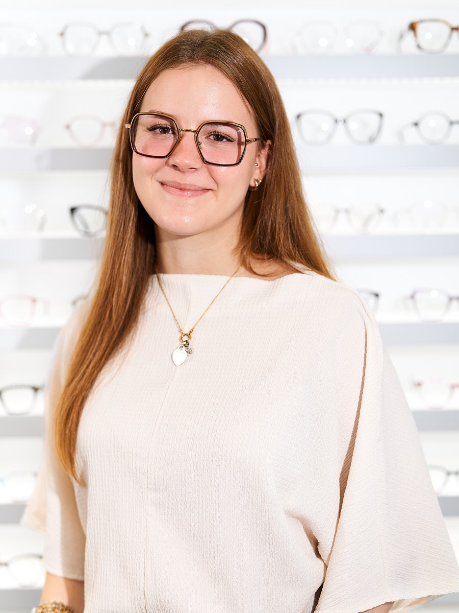 Optical team member wearing modern glasses with a focus on personal advice and individual eyewear selection.